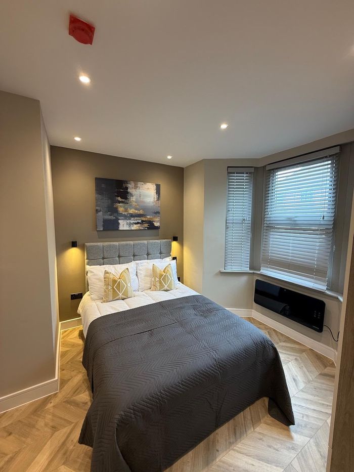 Finished bedroom with smooth plastered walls and ceiling downlights