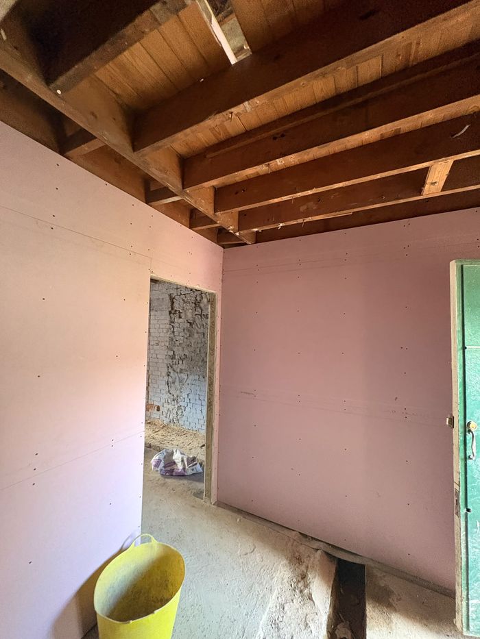 Fire-rated pink plasterboard fixed to new partition walls