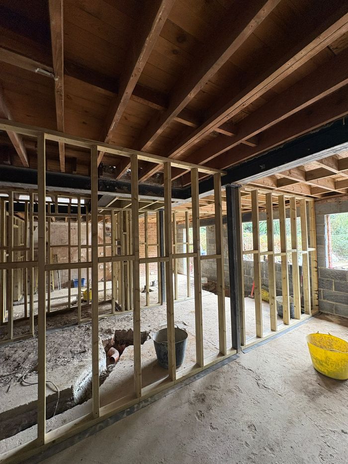 Timber stud partition framed under steel beams on the ground floor